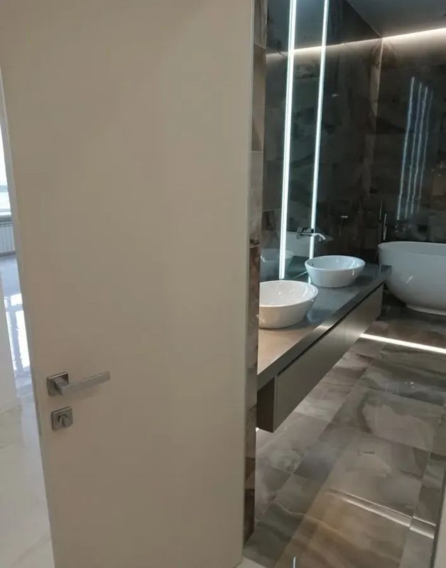Скрытая дверь под покраску у входа в ванную с подсветкой — фото с объекта BAKUN DOORS