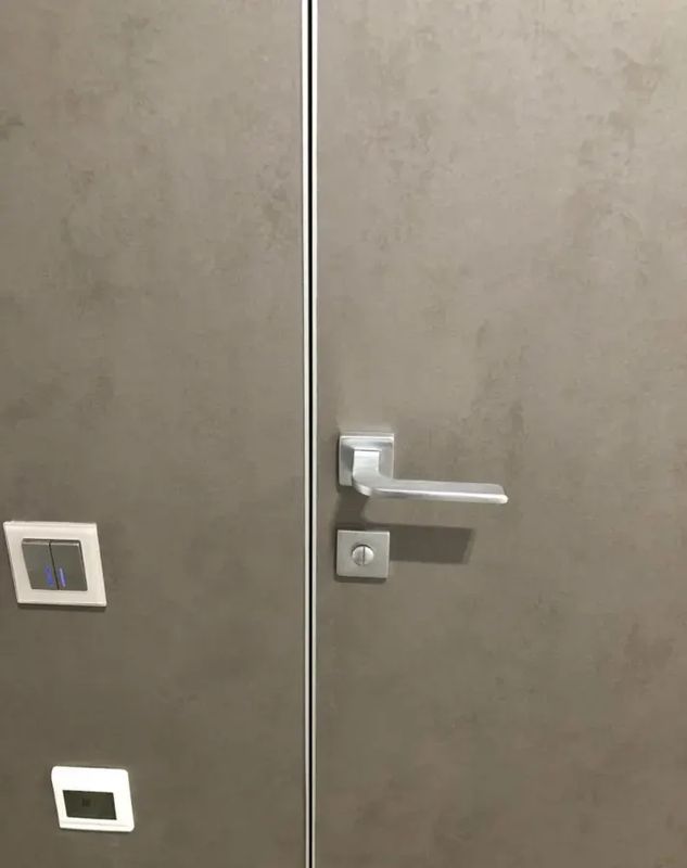Скрытая дверь под покраску HAUSDOORS крупным планом: кромка вровень со стеной — фото с объекта BAKUN DOORS