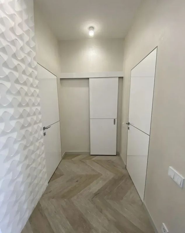 Скрытая дверь под покраску HAUSDOORS в коридоре с 3D-панелями — фото с объекта BAKUN DOORS