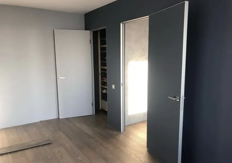 Скрытая дверь под покраску HAUSDOORS в тёмной стене — фото с объекта BAKUN DOORS