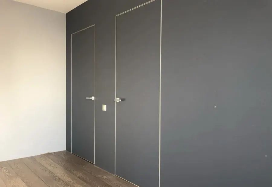Скрытая дверь под покраску HAUSDOORS две двери в тёмной стене — фото с объекта BAKUN DOORS