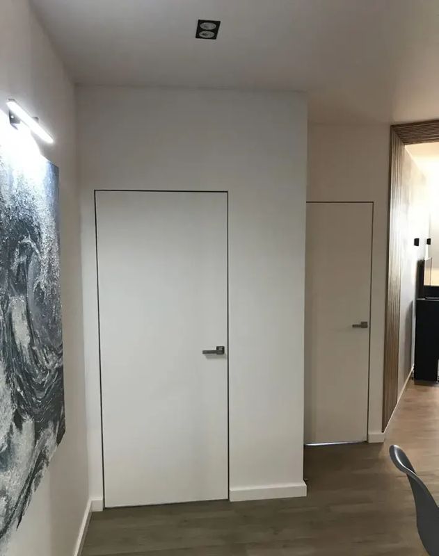Скрытая дверь под покраску в светлой прихожей — фото с объекта BAKUN DOORS